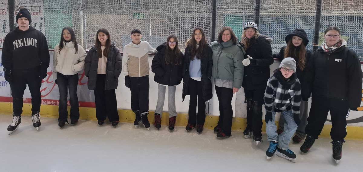 Spanische Schüler auf Schlittschuhen in einer Eishallte genießen die Winterfreuden beim deutschen Schüleraustausch