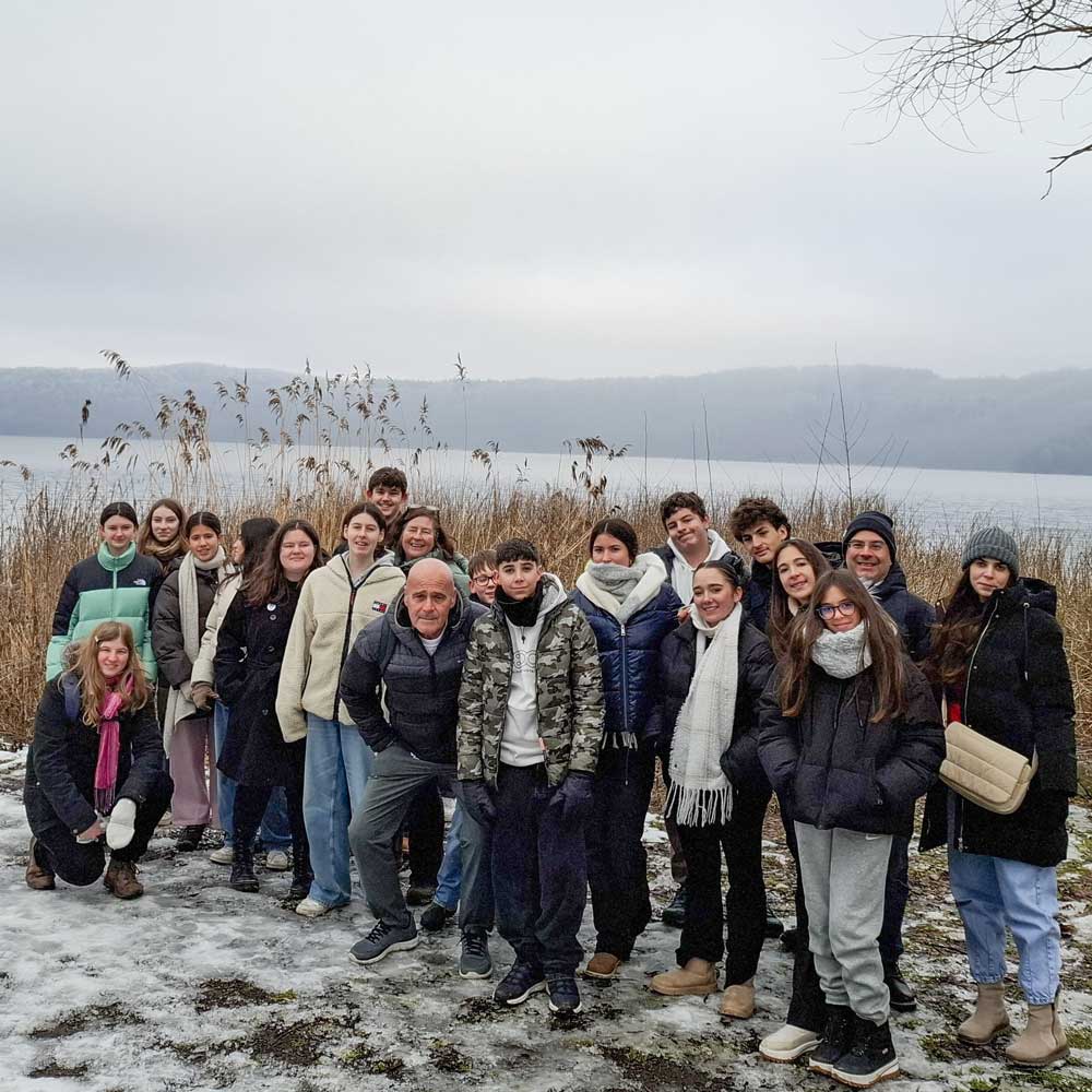 Gruppe von Schülern des Austauschs steht in verschneiter Landschaft vor Laacher See