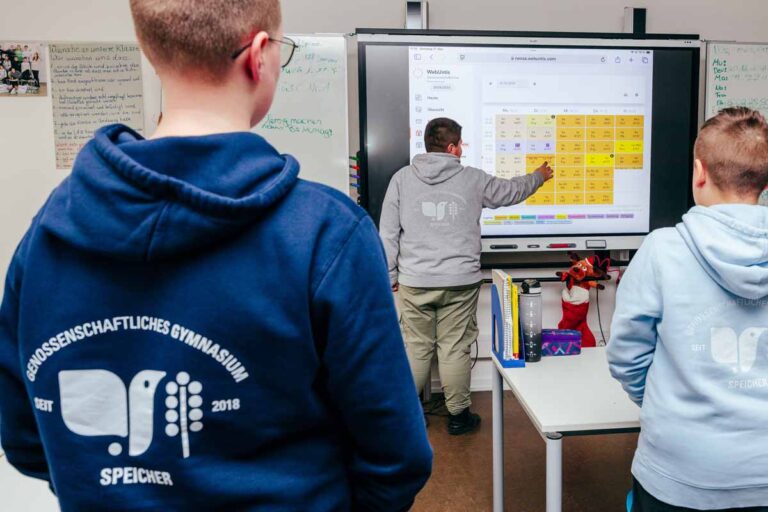 Schüler steht an elektronischer Tafel und erklärt einen Unterrichtsinhalt